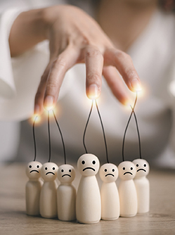 La main d'une femme manipule des individus représentés par des personnages en bois - MACSF