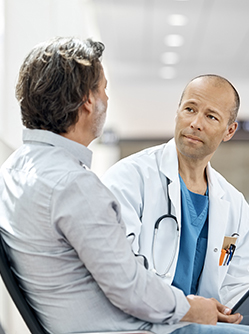 Un médecin discute avec un patient dans le couloir d'un hôpital - MACSF