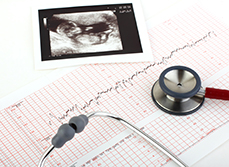 Echographie, tracé monitoring et stéthoscope posé sur un bureau - MACSF