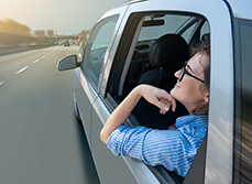 Femme assise à l'arrière d'une voiture autonome - MACSF
