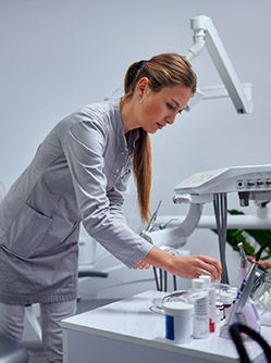 Une dentiste manipule des objets sur son bureau - MACSF