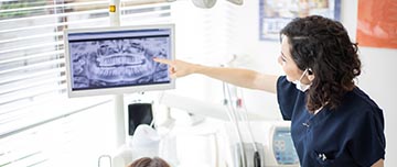 Une femme chirurgien-dentiste explique les soins à sa patiente - MACSF