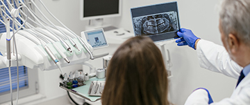 Le dentiste montre une radio dentaire à la patiente - MACSF