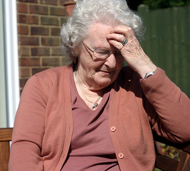 Une dame âgée se tient la tête - MACSF