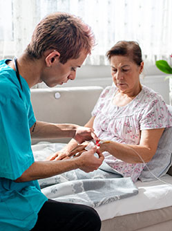 Un infirmier pose une perfusion au domicile d'une patiente - MACSF