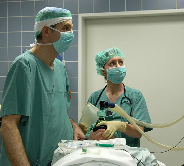 Une femme anesthésiste et un chirurgien avec un patient dans une salle d'opération - MACSF