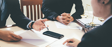 Trois personnes discutent autour d'une table - MACSF