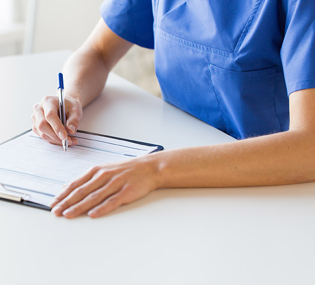 Une infirmière inscrit des informations sur un document - MACSF