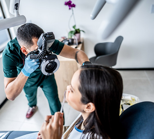 Un chirurgien-dentiste prend une photo de la bouche de sa patiente - MACSF