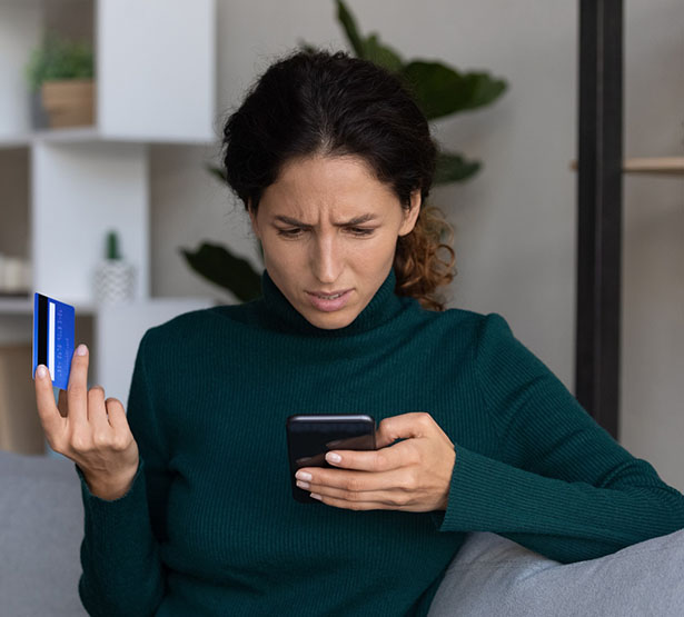 une femme consulte sont téléphone et constate une fraude à sa carte bancaire | MACSF