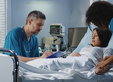 Jeune femme alitée à l'hôpital, entourée de deux soignants - MACSF