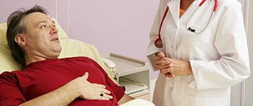 Un patient explique ses douleurs abdominales à une femme médecin - MACSF