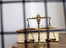 Un code pénal et la balance de la justice posés sur un bureau - MACSF