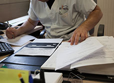 Un homme à son bureau examine des documents - MACSF