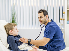 Un professionnel de santé ausculte un enfant à l'hôpital - MACSF