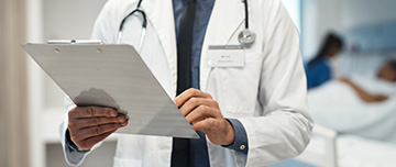 Le médecin prend connaissance de la lettre de liaison dans la chambre du malade - MACSF