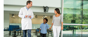 Un enfant marche à côté de sa mère et d'un médecin à l'hôpital - MACSF
