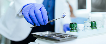 Un chirurgien-dentiste prend un miroir dentaire - MACSF