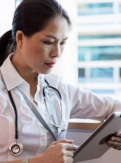 Une femme médecin regarde sa tablette - MACSF