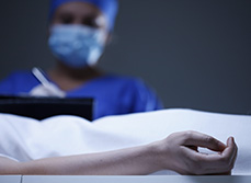 Gros plan sur le bras d'une défunte. Buste du médecin en second plan - MACSF