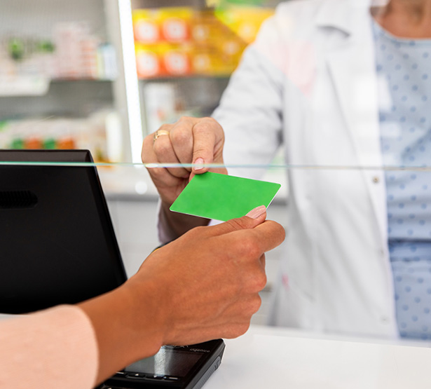 Une cliente tend une carte de fidélité à la pharmacienne - MACSF
