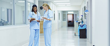 Deux agents hospitaliers discutent du dossier d'un patient - MACSF