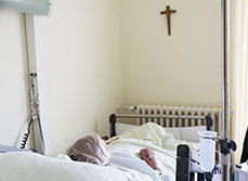 Une femme âgée alitée dans un lit d'hôpital - MACSF