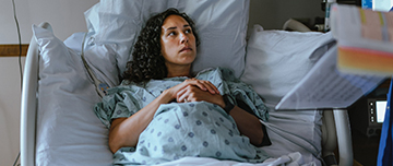 Une femme sur le point d'accoucher écoute les informations données par le professionnel de santé - MACSF