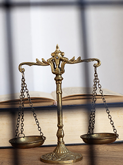 Un code pénal et la balance de la justice posés sur un bureau - MACSF