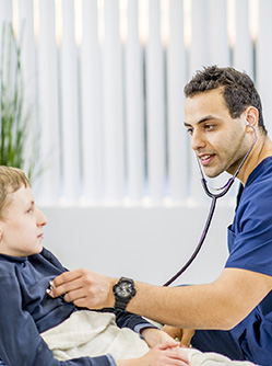 Un professionnel de santé ausculte un enfant à l'hôpital - MACSF