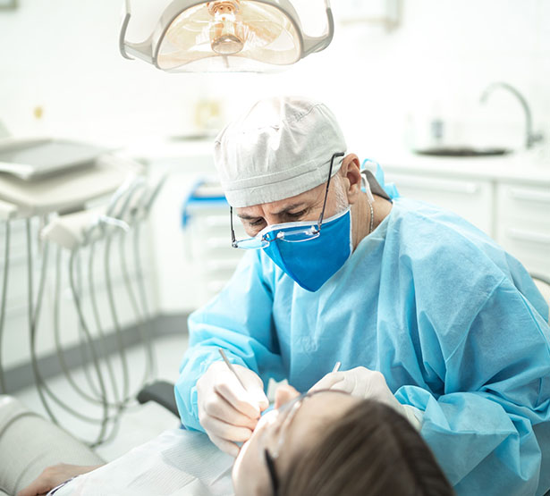Un chirurgien-dentiste pratique des soins sur une patiente - MACSF