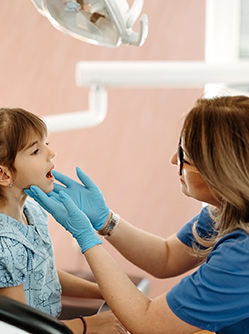 La dentiste examine les dents d'une fillette - MACSF