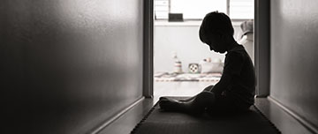Enfant triste assis dans le couloir de la maison - MACSF