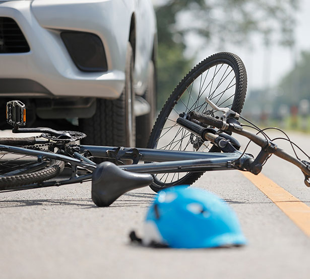 Une voiture arrêtée sur la route à côté d'un vélo accidenté - MACSF