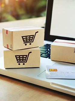 Une carte de crédit et des petites boîtes de colis sur un ordinateur portable - MACSF