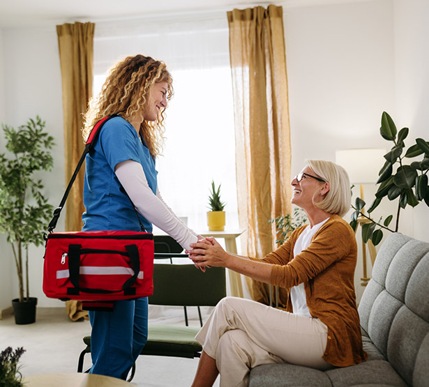 Une infirmière à domicile serre la main de la patiente - MACSF
