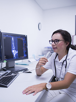 Une radiologue dicte un compte-rendu en visionnant les radios à l'écran - MACSF