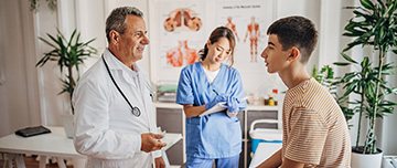 Un médecin discute avec un patient adolescent pendant qu'une infirmière prend des notes - MACSF
