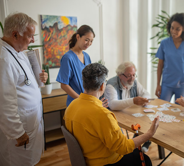 Une équipe soignante observe les résidents d'une EHPAD pendant un jeu de cartes - MACSF