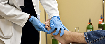 Un médecin auscule le pied d'un homme - MACSF