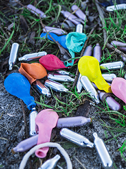 Des cartouches de gaz hilarant et des ballons dégonflés étalés dans l'herbe - MACSF