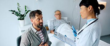 Le fils d'un patient alité à l'hôpital discute avec une femme médecin - MACSF