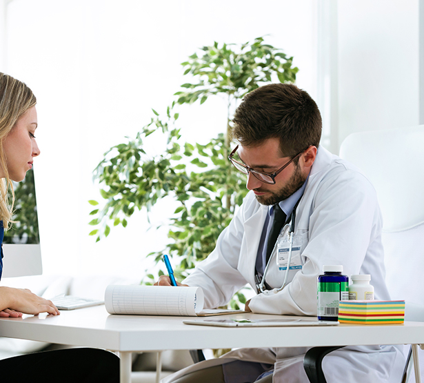 Un médecin prend des notes pendant sa consultation avec une patiente - MACSF