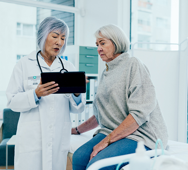 Deux femmes d'âge mûr, patiente et médecin, contrôlent des résultats médicaux sur une tablette - MACSF