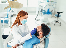 Une dentiste examine les dents des son patient - MACSF