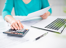 Une main de femme utilisant une calculatrice, en train de saisir ou vérifier des chiffres - MACSF