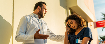 Médecin en colère parlant à une infirmière devant l’hôpital - MACSF