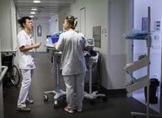 Une infirmière et une aide-soignante discutent dans le couloir de l'hôpital - MACSF