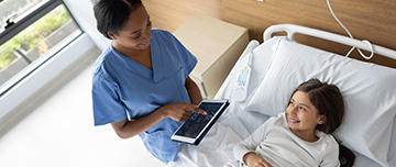 Une infirmière surveille les signes vitaux d’une fillette à l’aide d’une tablette numérique à l’hôpital - MACSF