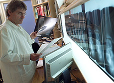 Un radiologue observe des clichés et des documents - MACSF